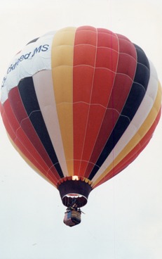 Another-copy-of-the-same-photo-of-that-hot-air-balloon-with-red-white-yellow-and-black--verticle-stripes--and-a-flame-shooting-up-inside-the-balloon-can-be-seen