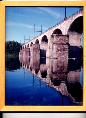 my-photo-of-a-railroad-bridge-with-large-open-tan-arches--which-is-going-over-the-unusually-placid-Delaware-River--located-in-Pennsylvania--a-perfect-reflection-of-the-arches-of-the-bridge-can-be-seen-in-the-mirror-like-river"